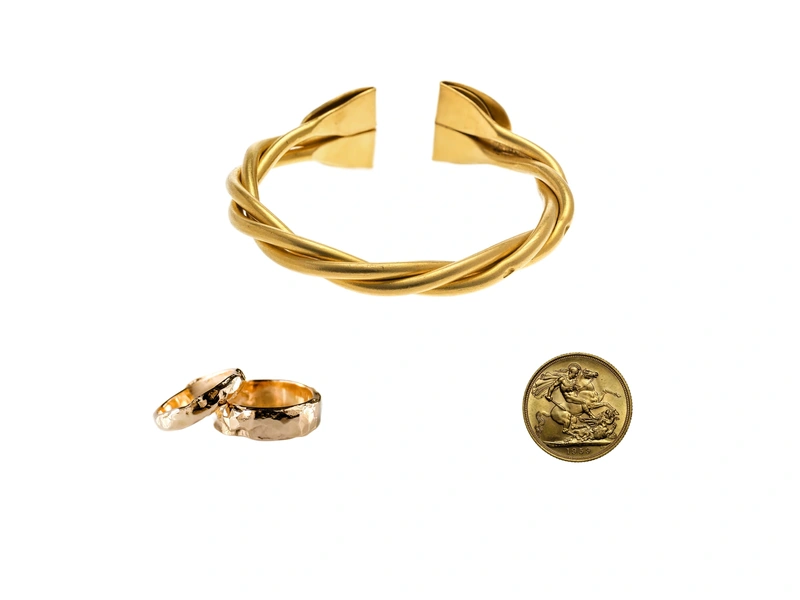 Fotografierte Erbstücke aus Goldschmuck und Goldmünze, zusammengestellt als Beispiel